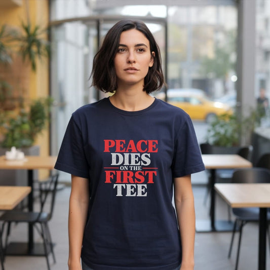 Woman wearing navy t-shirt with red and white text reading "PEACE DIES ON THE FIRST TEE".