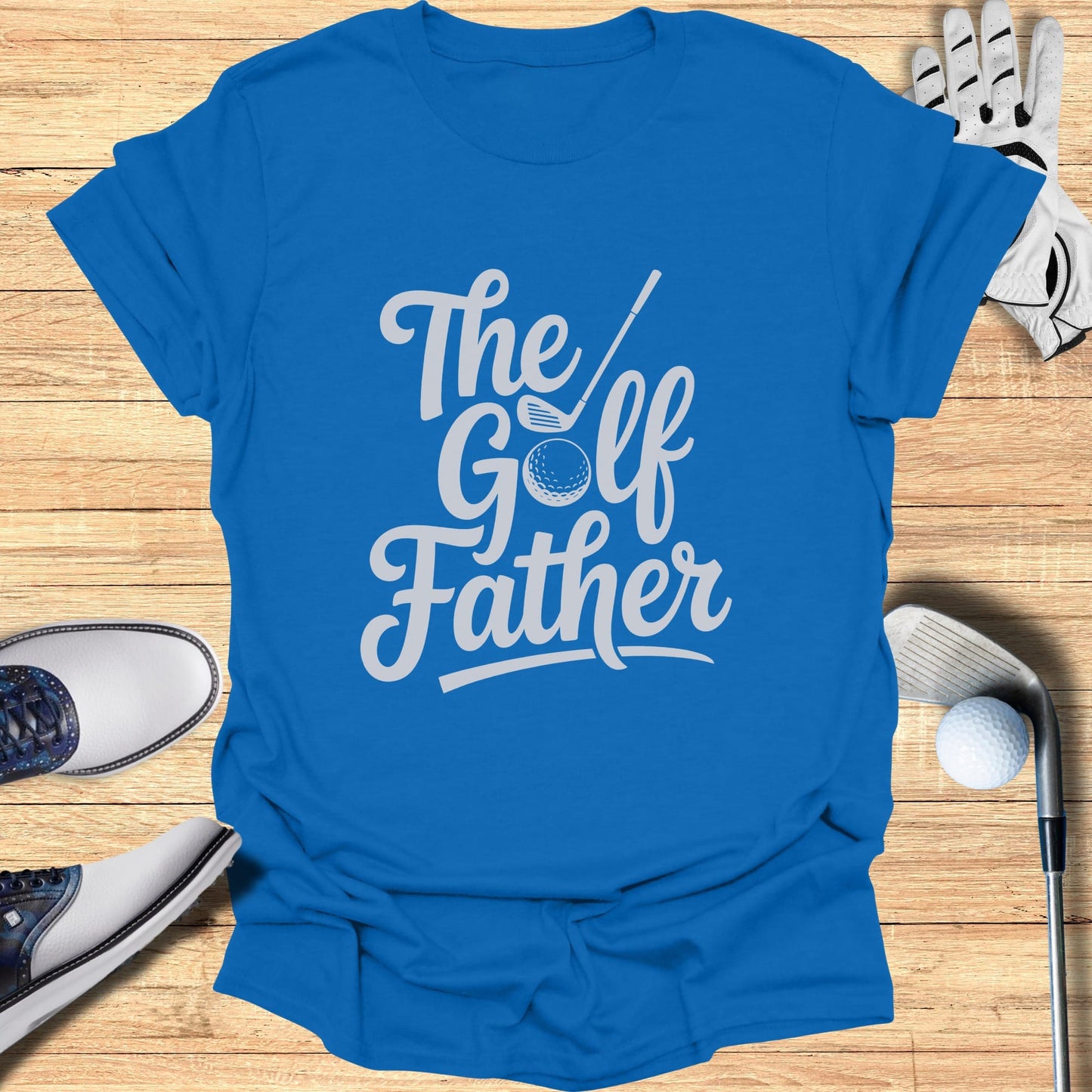 Blue t-shirt with white text "The Golf Father" with golf equipment.