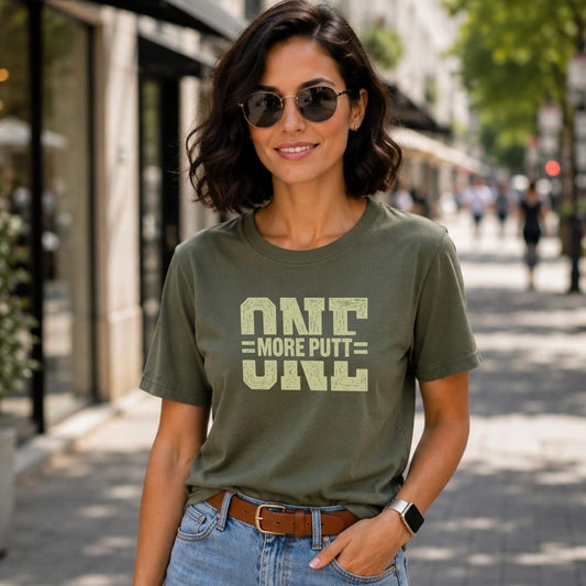 Woman wearing a green t-shirt with "ONE MORE PUTT" text.