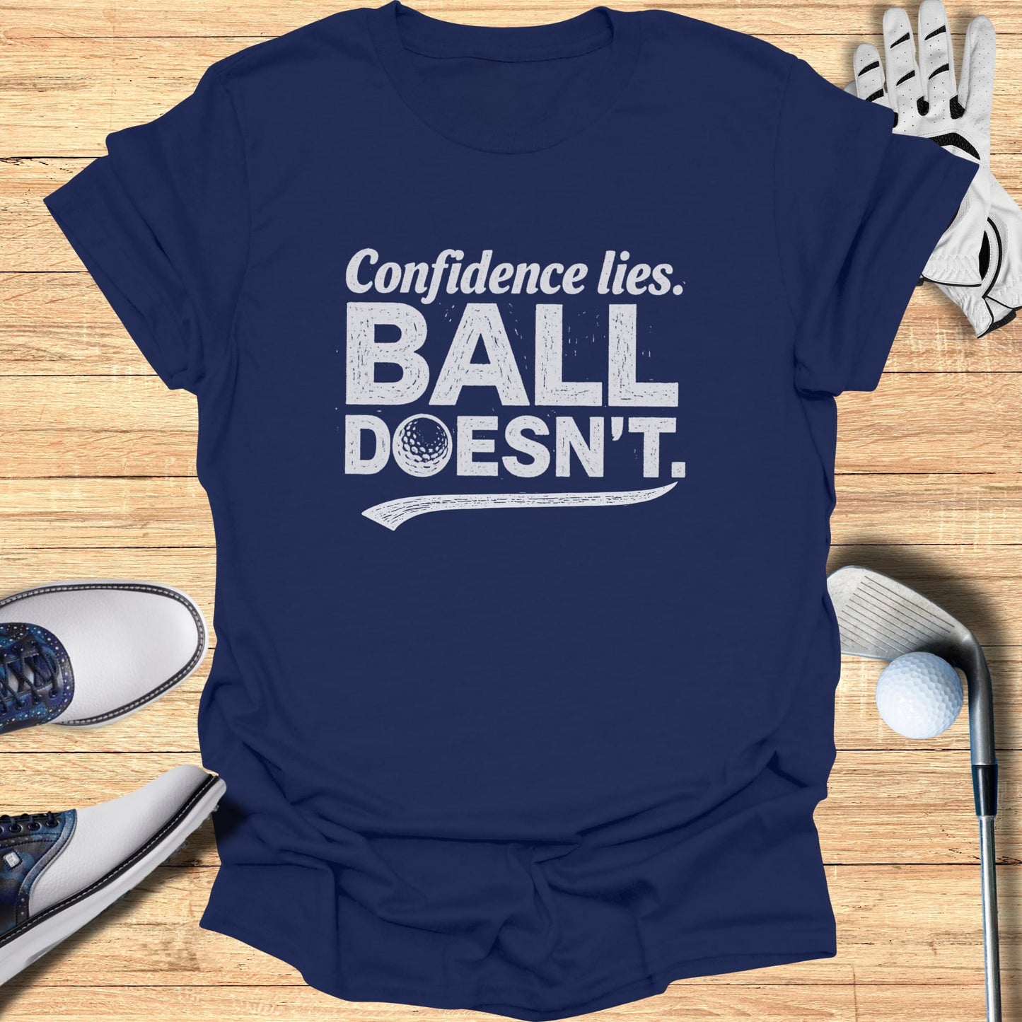 Navy t-shirt with white text "Confidence lies. BALL DOESN'T." and a golf ball.