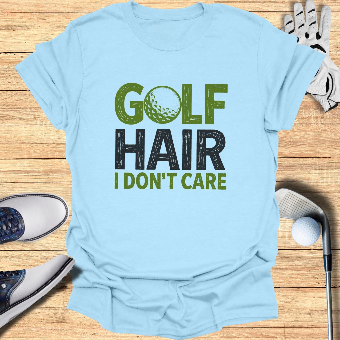 Light blue t-shirt with "Golf Hair I Don't Care" text and golf accessories.