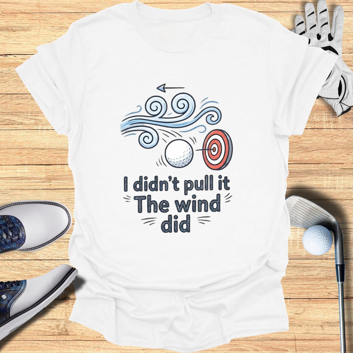 White t-shirt with "I didn't pull it The wind did" text and golf imagery.