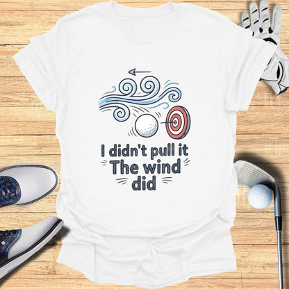 White t-shirt with "I didn't pull it The wind did" text and golf imagery.