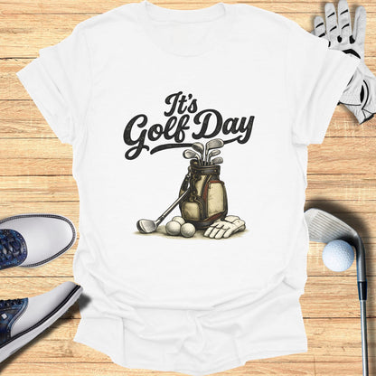 White t-shirt with "It's Golf Day" text above a golf bag with clubs and balls.