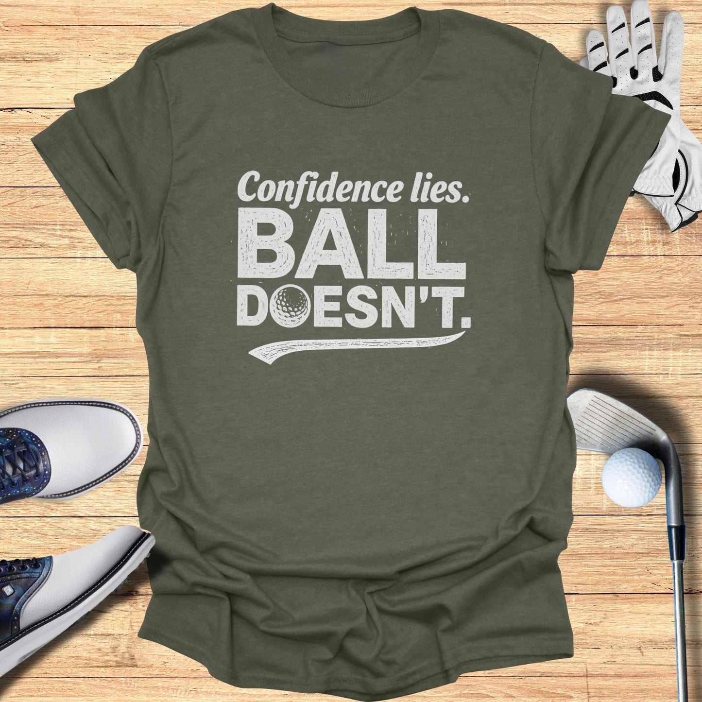 T-shirt with "Confidence lies. BALL DOESN'T." text and golf accessories.