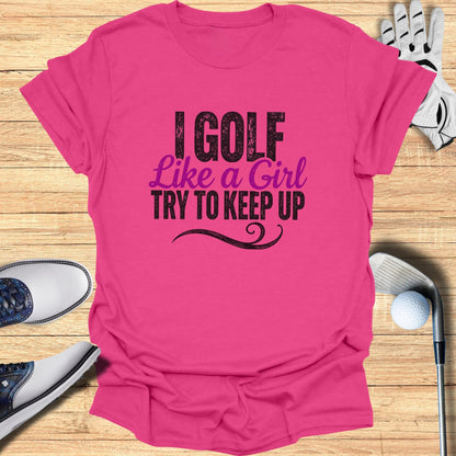Pink t-shirt with "I Golf Like A Girl Try To Keep Up" text, with golf equipment.