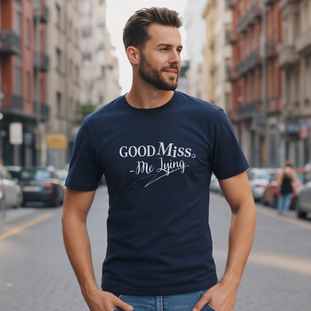 Navy t-shirt with "GOOD Miss - Me Lying" text, worn by a man outdoors.