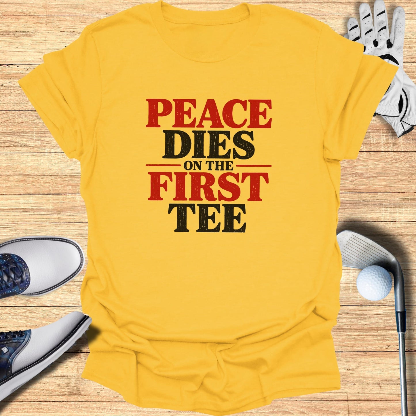 Yellow t-shirt with "Peace Dies On The First Tee" text, golf clubs and shoes.