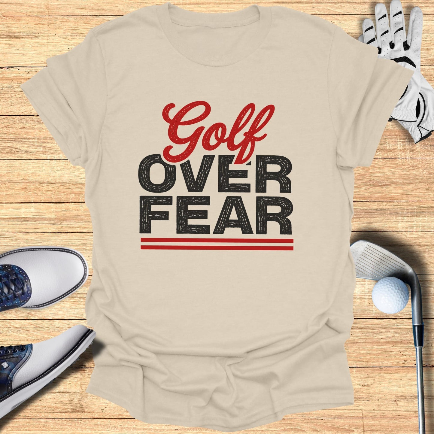 Light beige t-shirt with "Golf Over Fear" graphic and golf accessories.