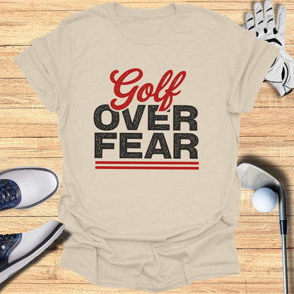 Light beige t-shirt with "Golf Over Fear" graphic and golf accessories.