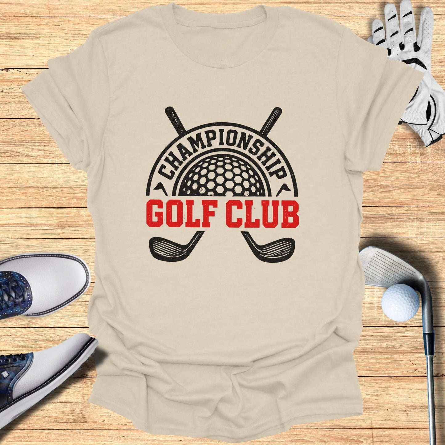 Championship Golf Club logo on a tan t-shirt with golf accessories.