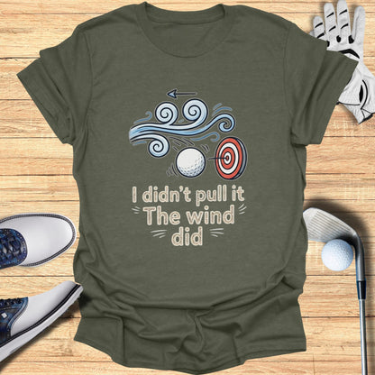 T-shirt with graphic of golf ball and target with wind and text.
