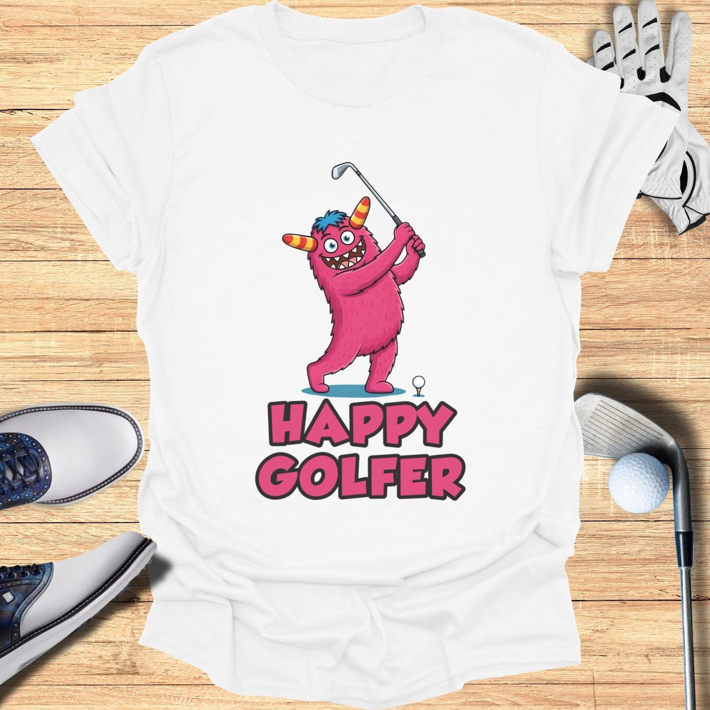 Pink monster swinging a golf club on a white t-shirt, with text "HAPPY GOLFER".