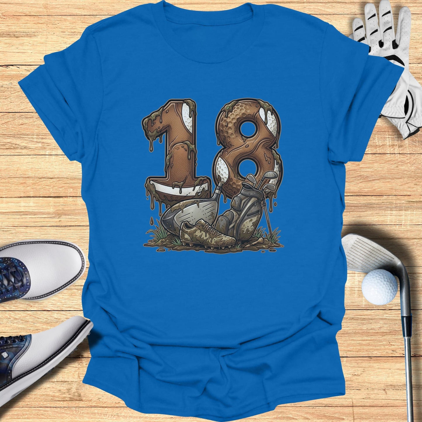 Blue t-shirt with '18' design featuring a football, golf clubs, and golf ball in mud.