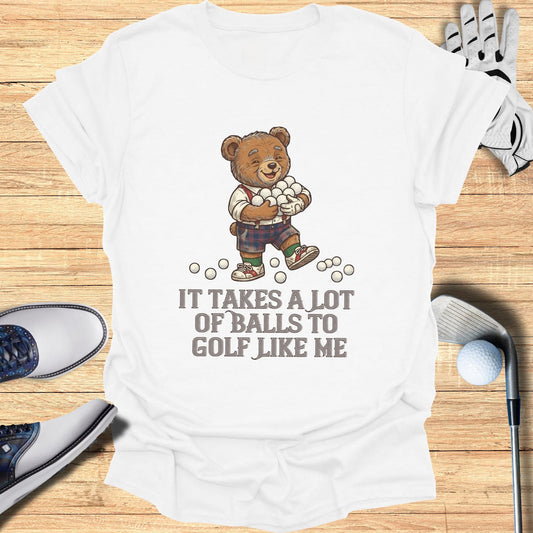 White t-shirt with a cartoon bear holding golf balls and the text "It takes a lot of balls to golf like me".