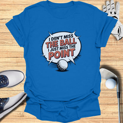 Blue t-shirt with text "I DON'T MISS THE BALL I JUST MISS THE POINT" and golf imagery.