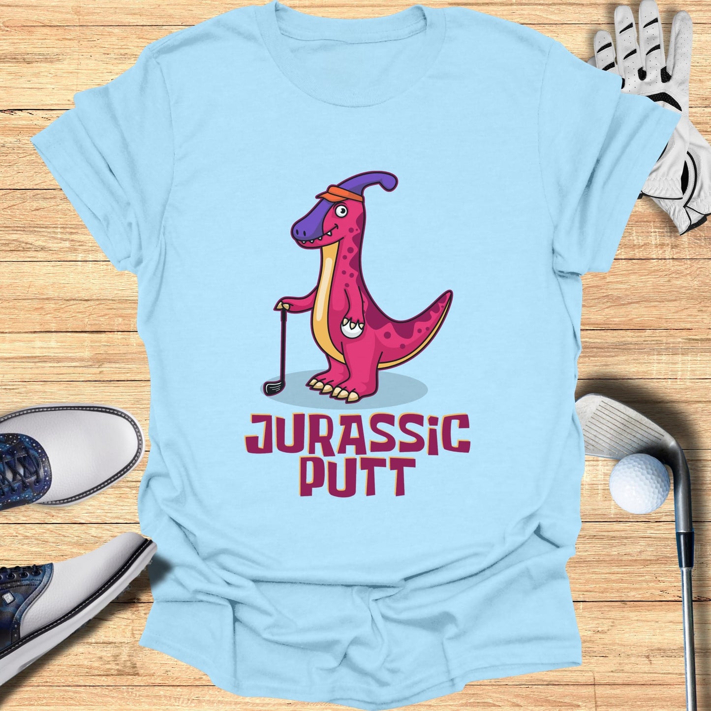 Light blue t-shirt with cartoon dinosaur golfing, "Jurassic Putt" text.