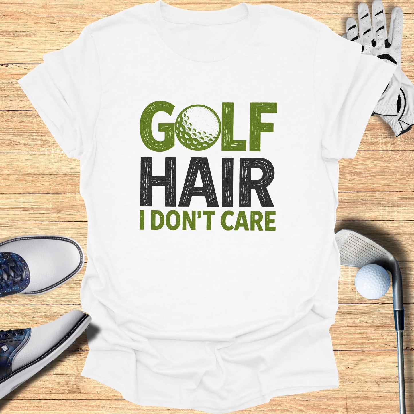 White t-shirt with "GOLF HAIR I DON'T CARE" graphic and golf accessories.