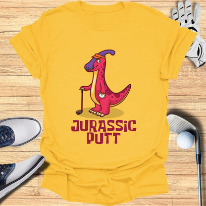 Yellow t-shirt with "Jurassic Putt" text and a cartoon dinosaur golfer.