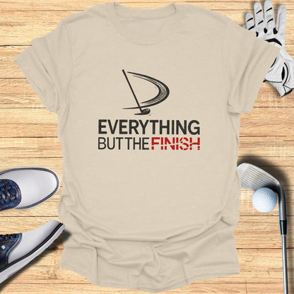 T-shirt with "EVERYTHING BUT THE FINISH" text and golf items.