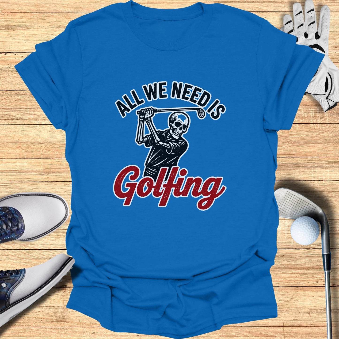 Blue t-shirt with a skeleton golfer graphic and "All We Need Is Golfing" text.