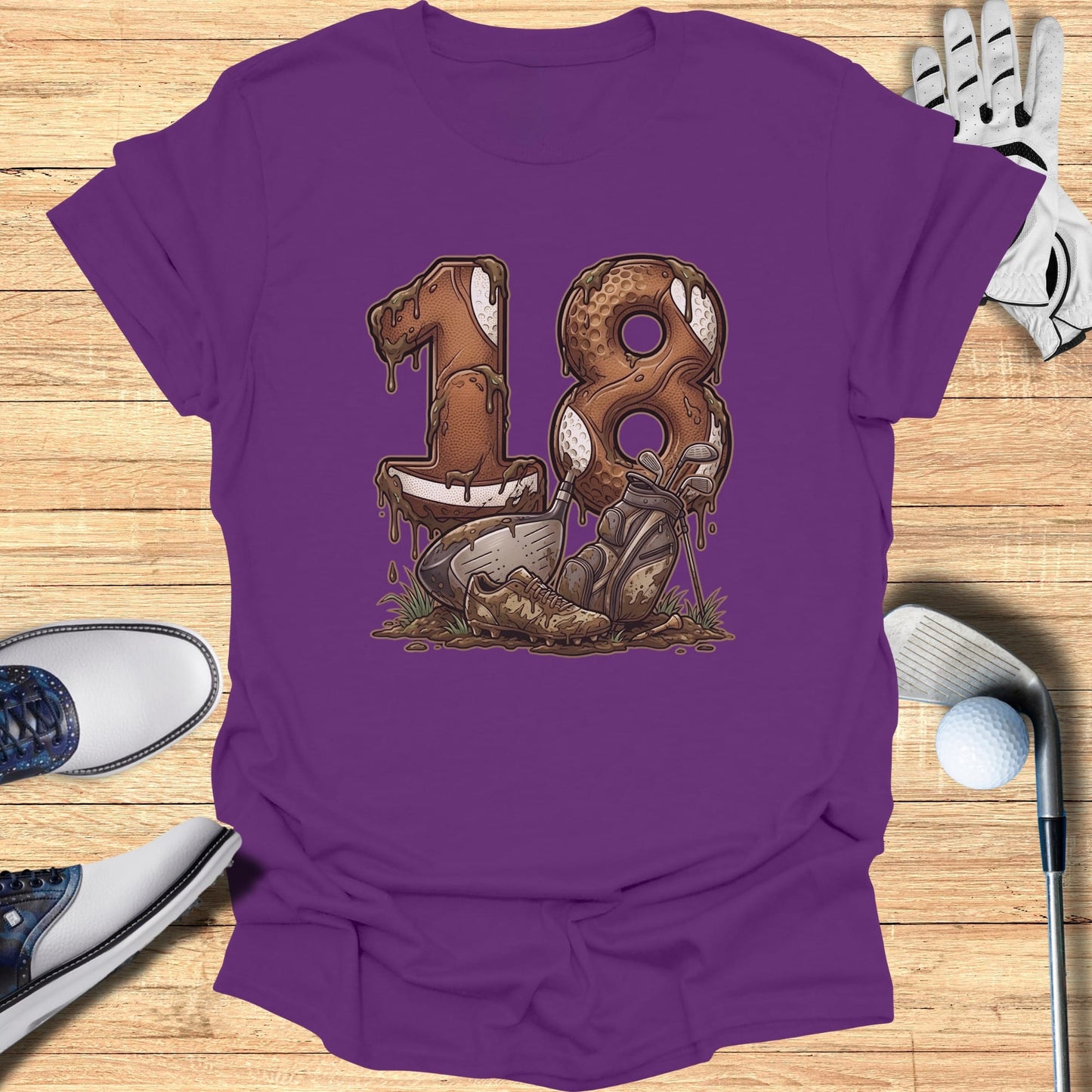 Purple t-shirt with "18" design made of chocolate and dirt, featuring golf clubs and balls.