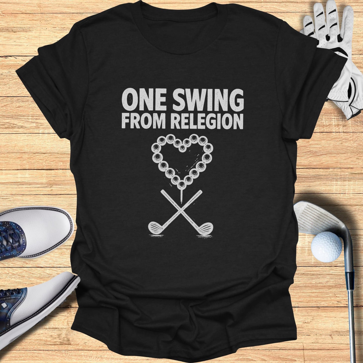 Black t-shirt with "ONE SWING FROM RELEGION" and crossed golf clubs with a heart.