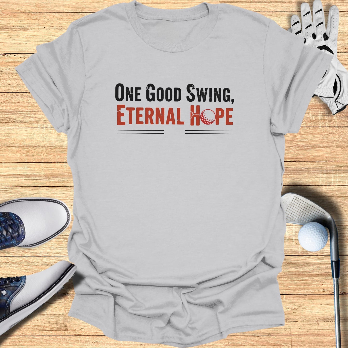 Gray t-shirt with "One Good Swing, Eternal Hope" and golf ball graphic.