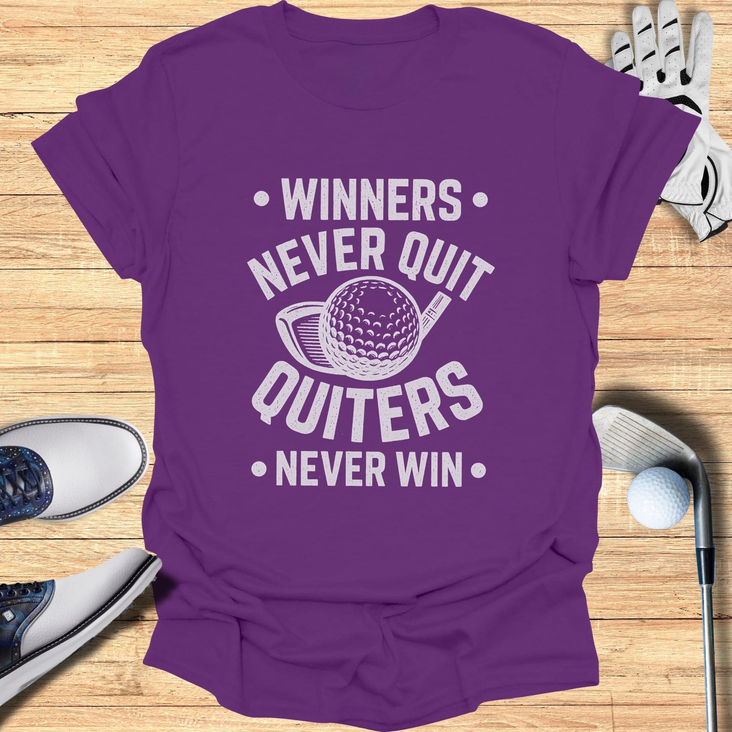 Purple t-shirt with white text "Winners Never Quit Quitters Never Win" and golf imagery.