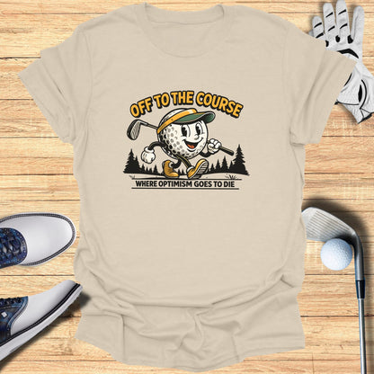 T-shirt with a cartoon golfer and text "OFF TO THE COURSE WHERE OPTIMISM GOES TO DIE".