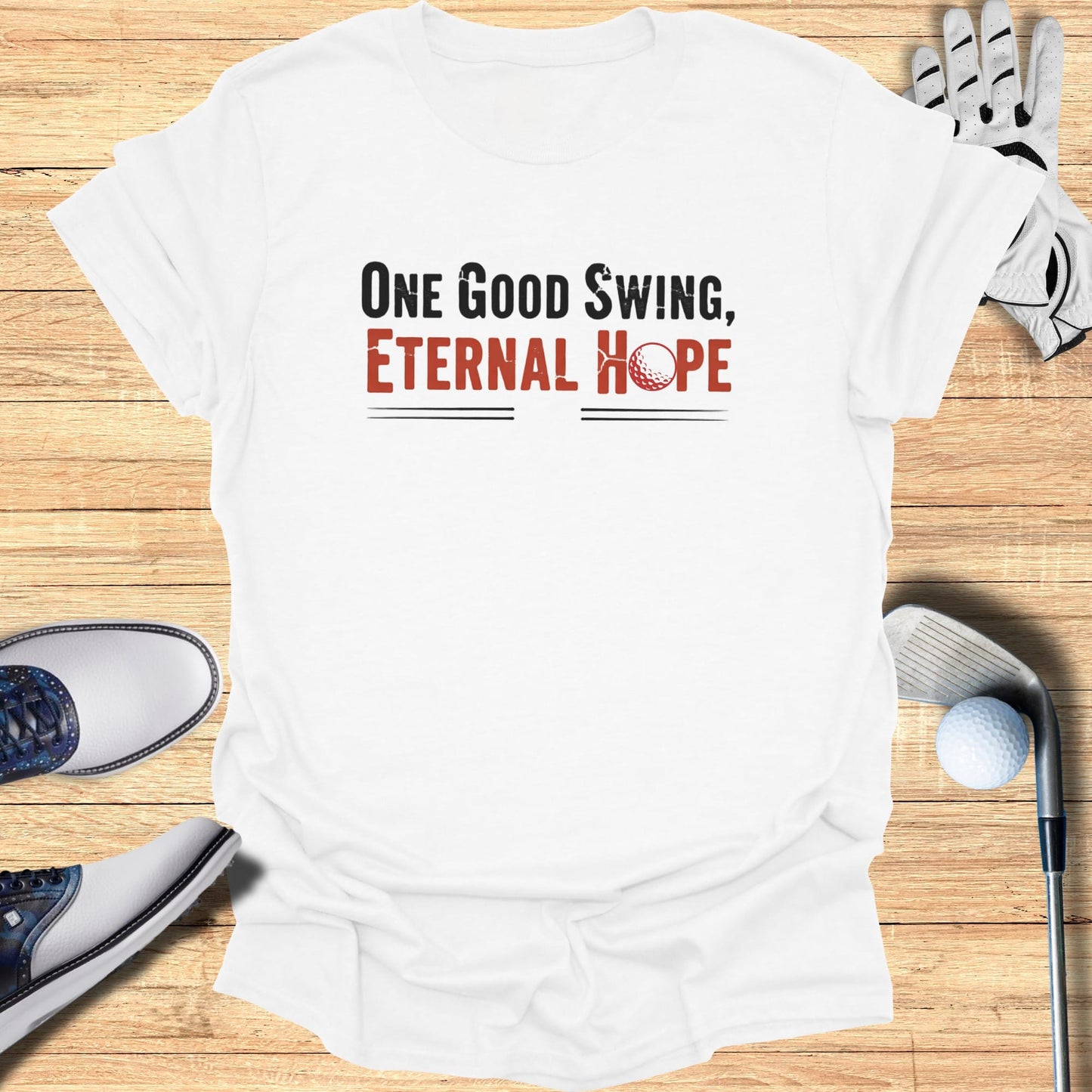 White t-shirt with "One Good Swing, Eternal Hope" text and golf accessories.