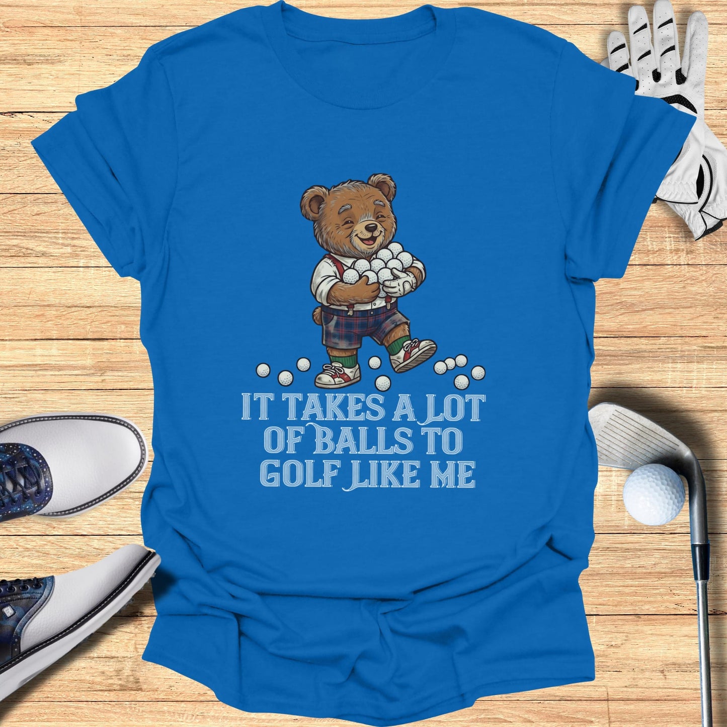 Blue t-shirt with a bear carrying golf balls and text: "It takes a lot of balls to golf like me."