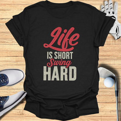 Black t-shirt with red text "Life is Short Swing Hard" and golf accessories.