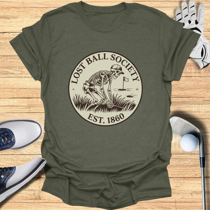 "Lost Ball Society" logo with skeleton golfing on olive green t-shirt.
