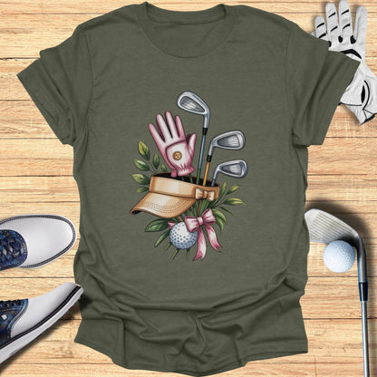 Golf club arrangement with visor, glove, ball, and pink ribbon.