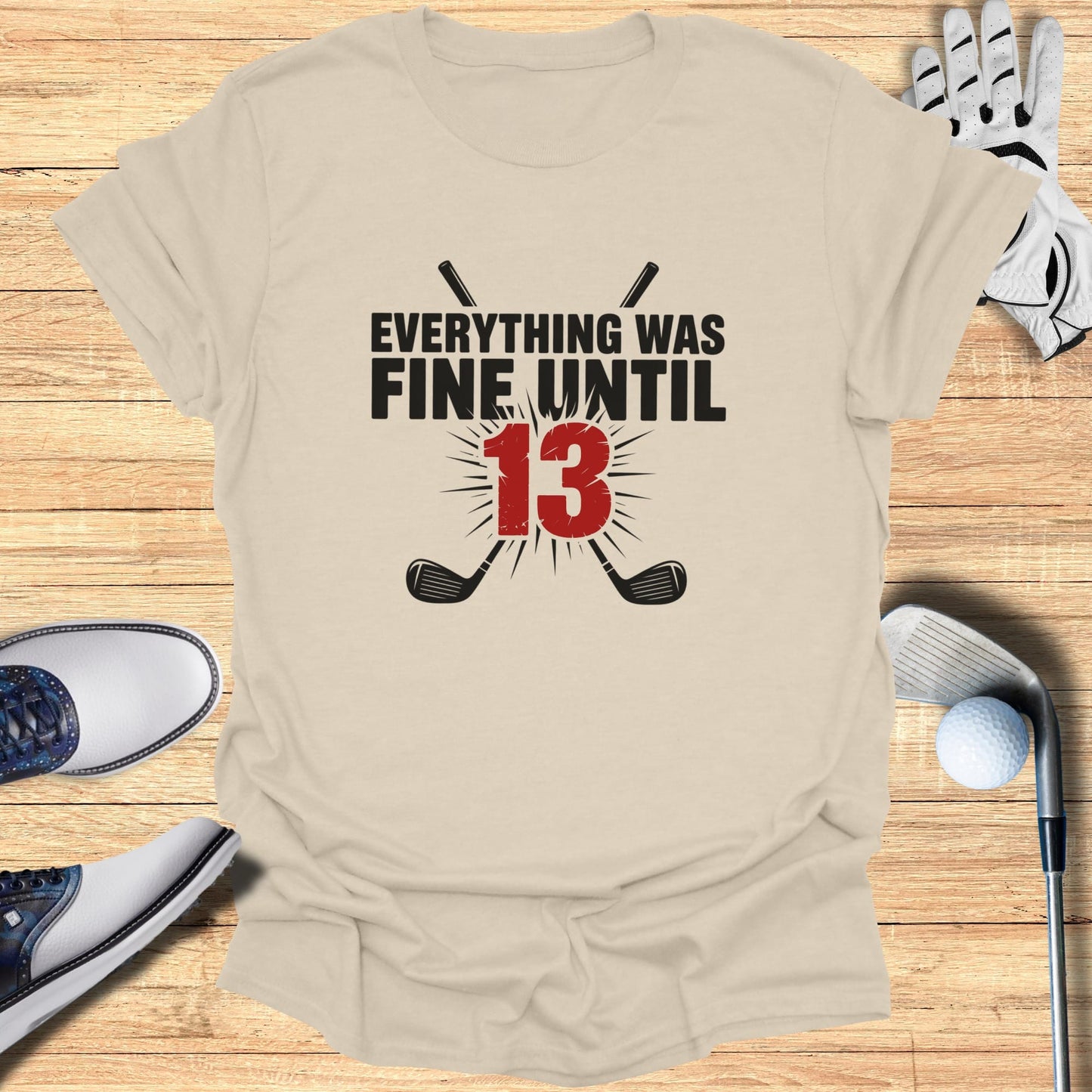 T-shirt with text "EVERYTHING WAS FINE UNTIL 13" and crossed golf clubs.