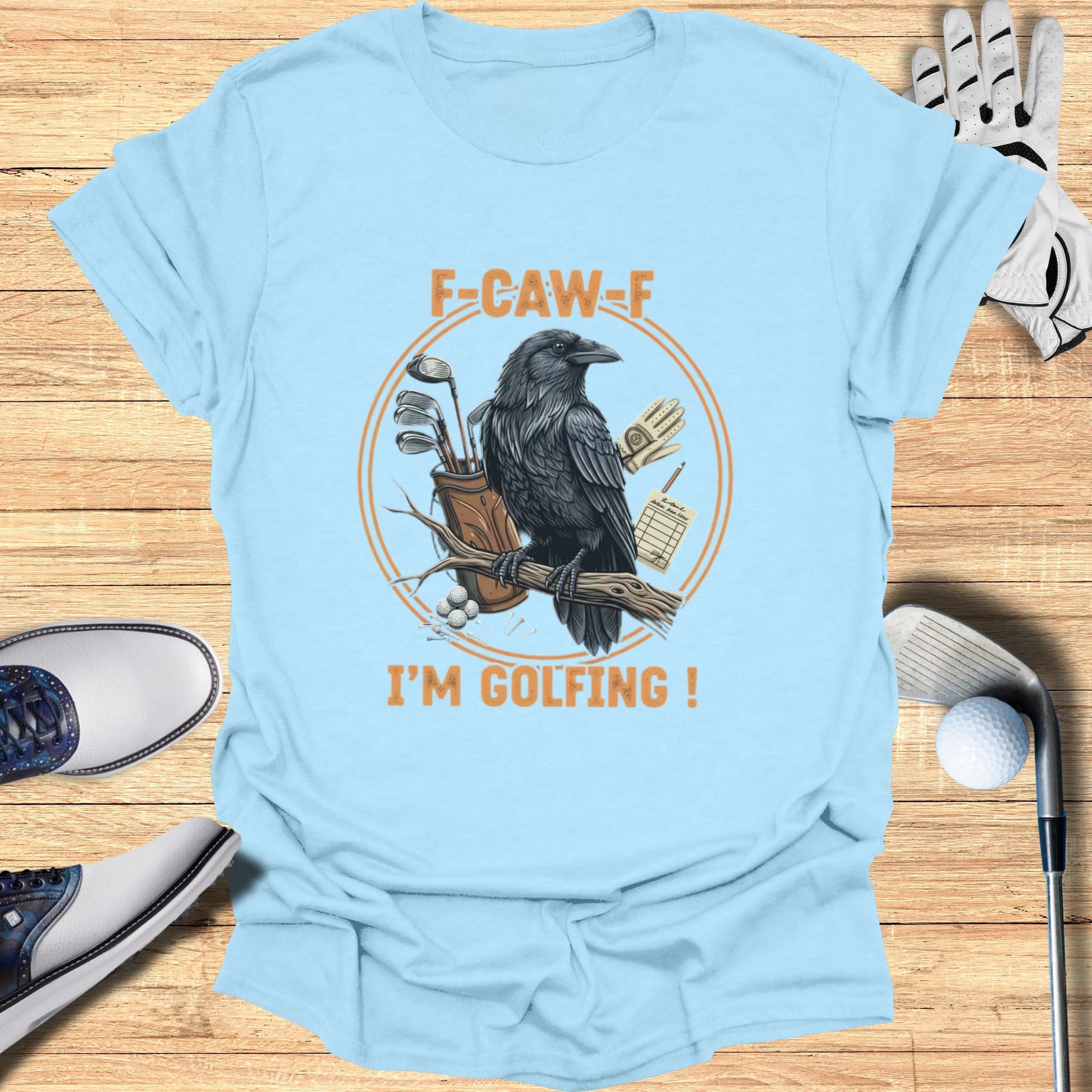 Light blue t-shirt with a raven and golf items, saying "F-CAW-F I'M GOLFING!"