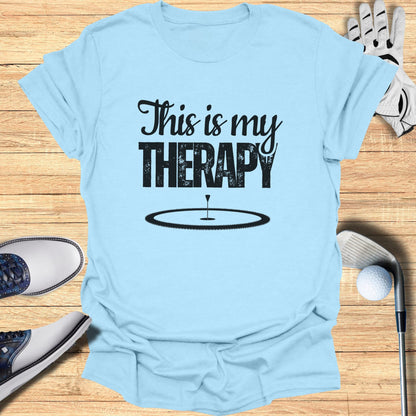 Light blue t-shirt with "This is my THERAPY" and a golf hole graphic.