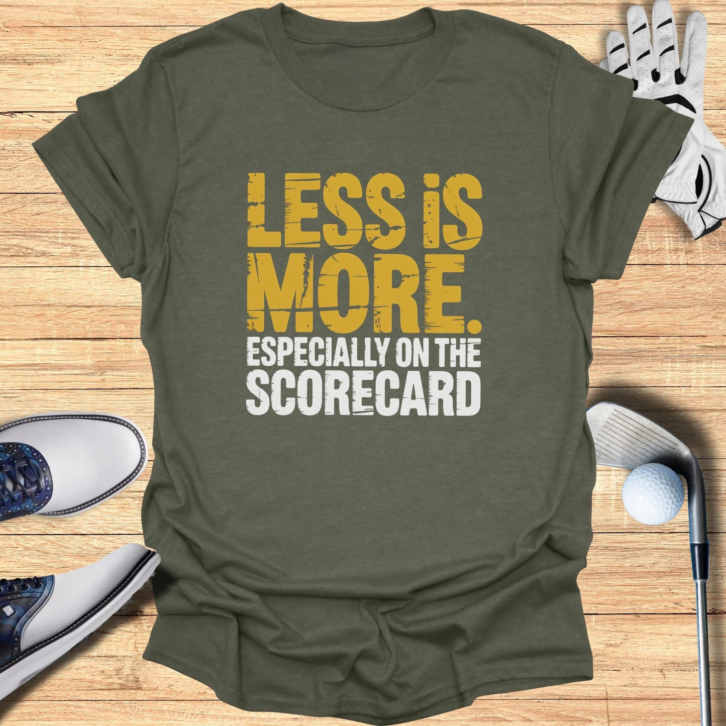 Green t-shirt with "LESS IS MORE ESPECIALLY ON THE SCORECARD" text.