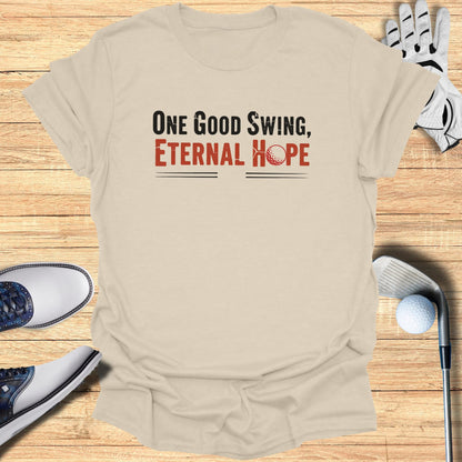 Beige t-shirt with "One Good Swing, Eternal Hope" text and golf items.