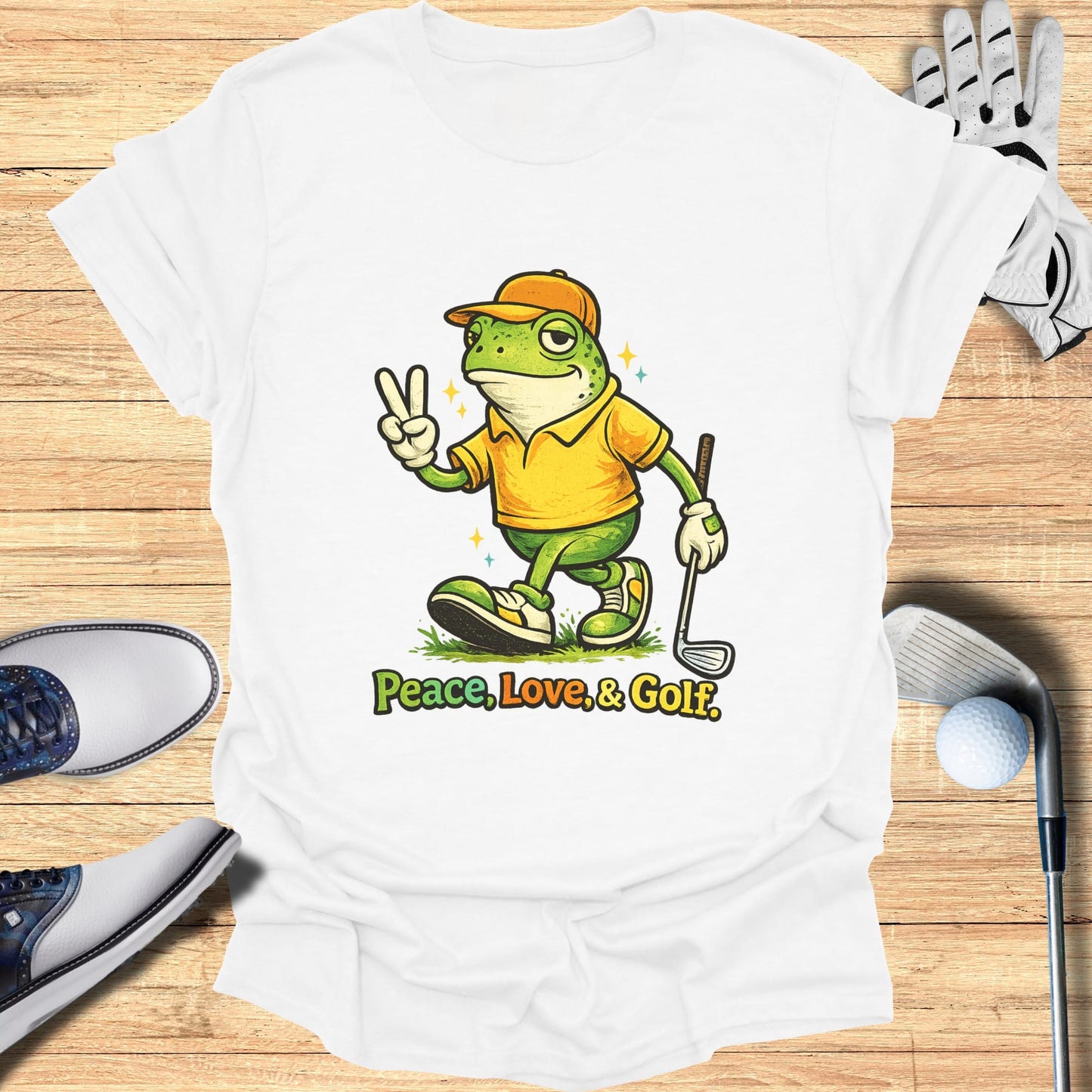 Green frog in a yellow shirt and baseball cap doing a peace sign next to golf clubs.