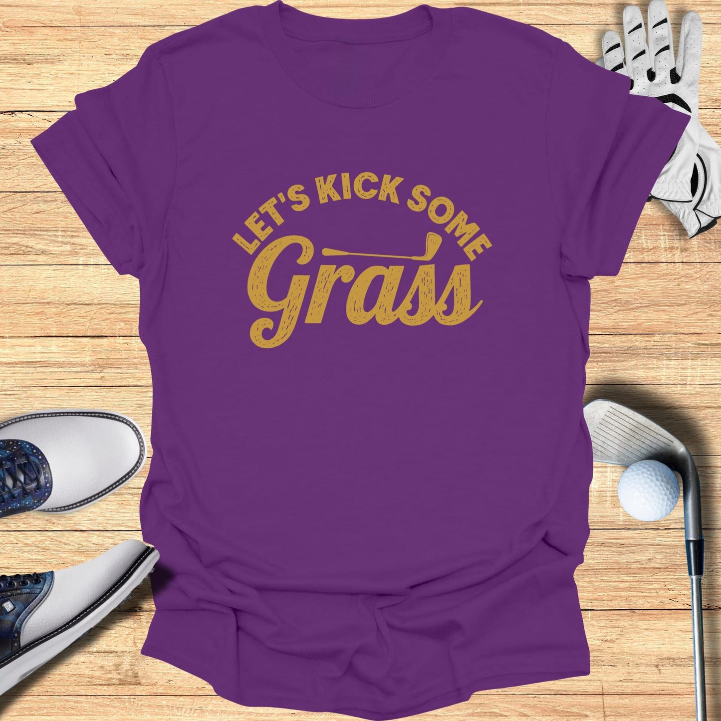 Purple t-shirt with yellow text reading "Let's Kick Some Grass".