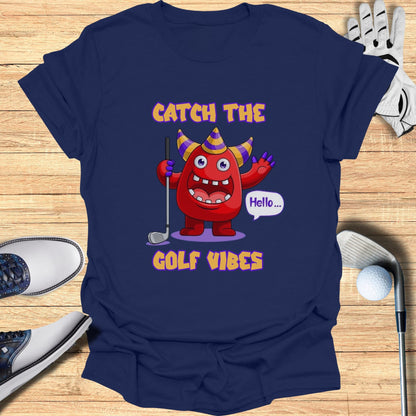 Cartoon monster in party hat saying "Hello" on a navy t-shirt with "GOLF VIBES".
