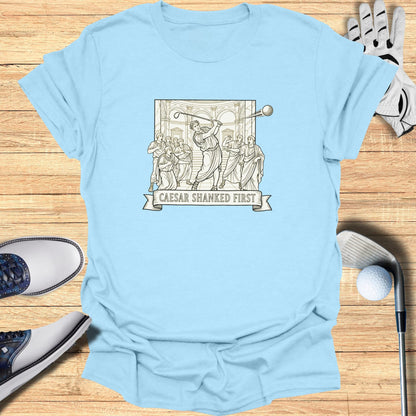 Light blue t-shirt with Roman figures playing golf and text "Caesar Shanked First".