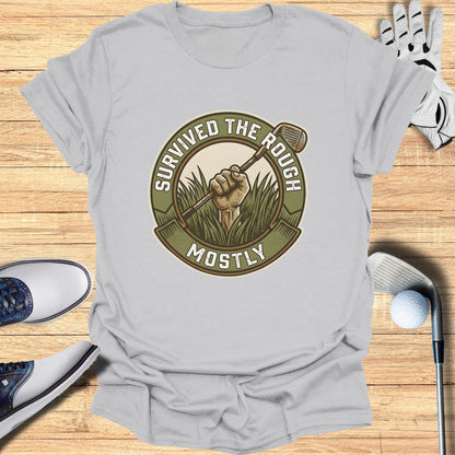 T-shirt with "Survived the Rough Mostly" text and golf club in grass.