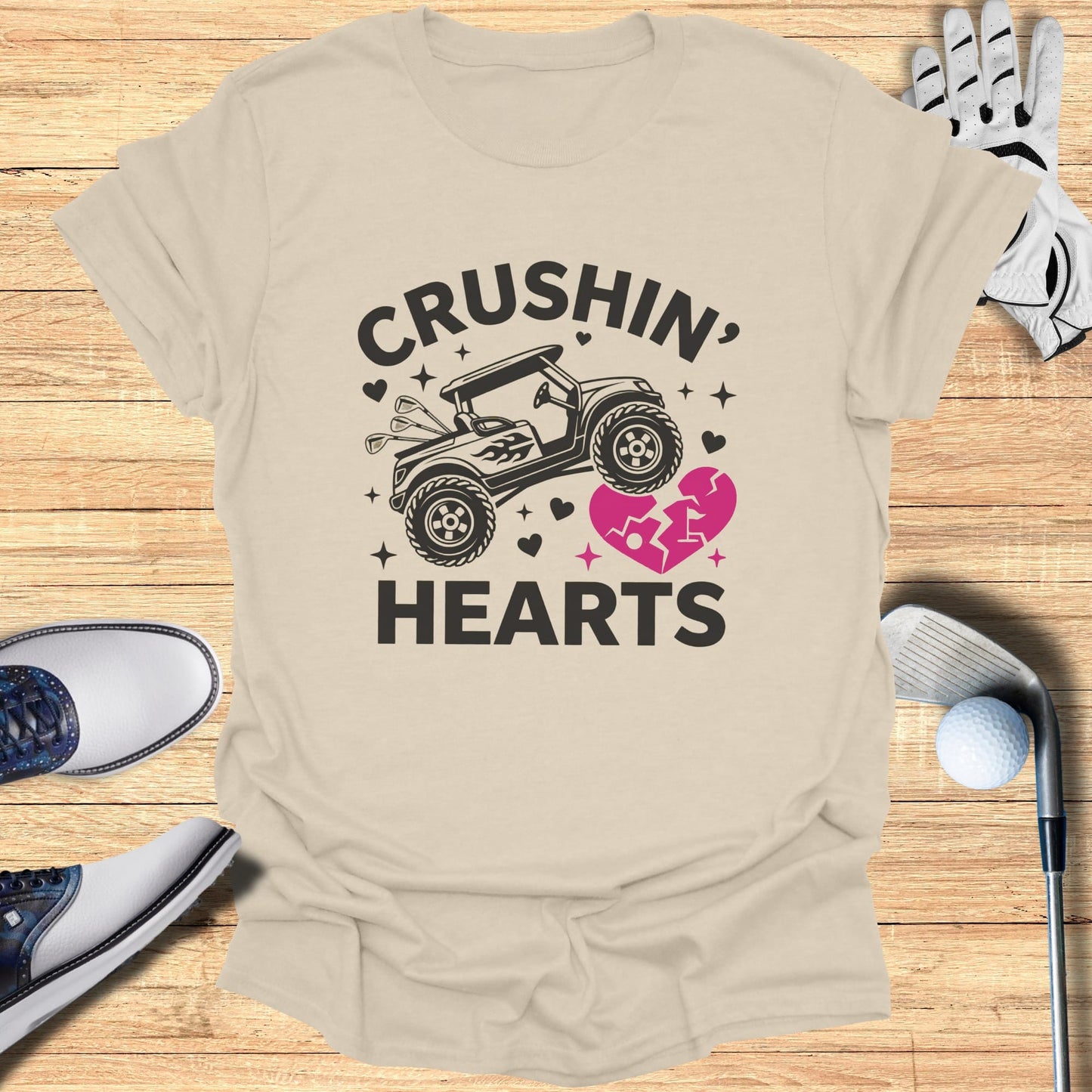 Golf cart graphic with "Crushin' Hearts" text on a beige t-shirt.