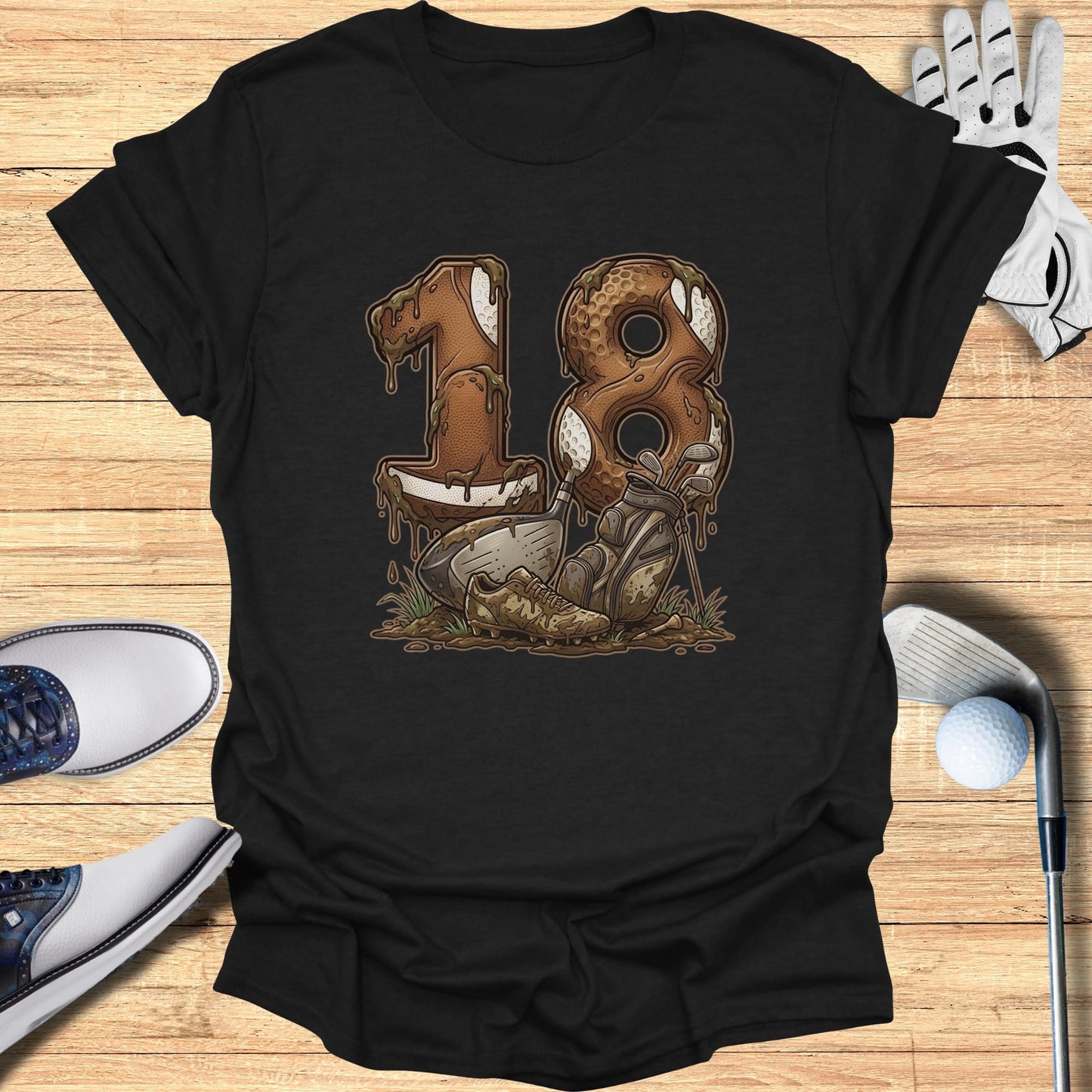 Black t-shirt with "18" graphic featuring golf clubs, shoes, and a ball in mud.