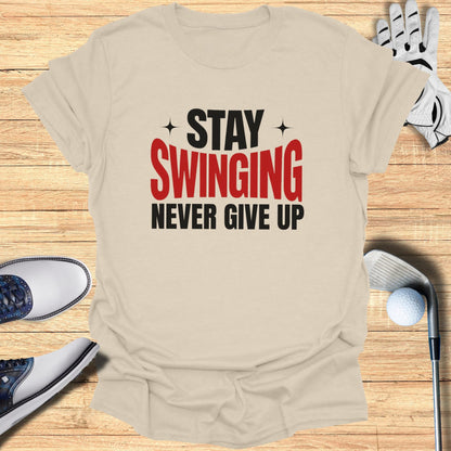 T-shirt with "Stay Swinging Never Give Up" text, surrounded by golf clubs and shoes.