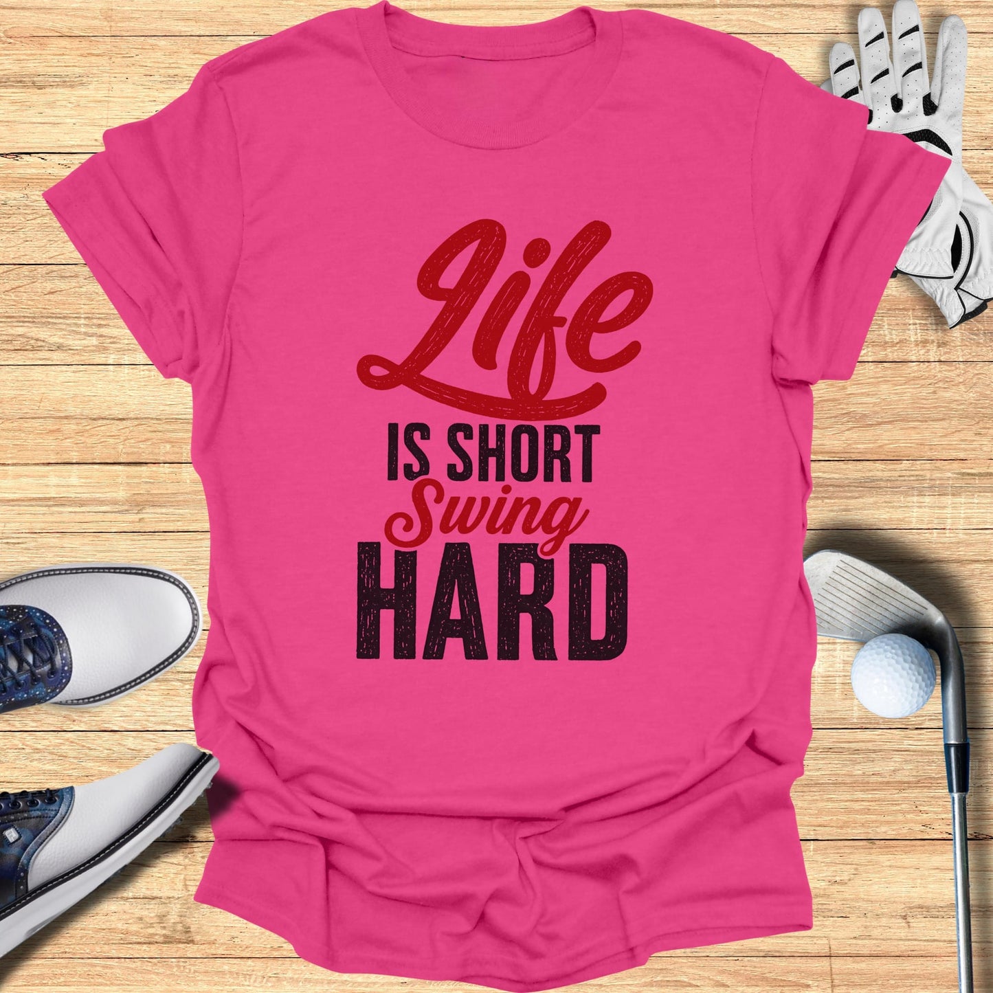 Pink t-shirt with "Life is Short Swing Hard" text, golf clubs, and shoes.
