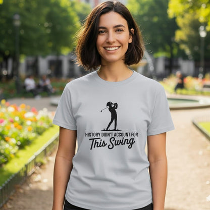 Woman wearing a grey t-shirt with a golfer silhouette and "History Didn't Account For This Swing" text.